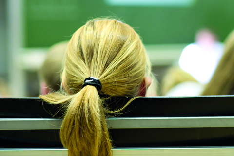 Hinterkopf einer Person mit blondem Haarzopf